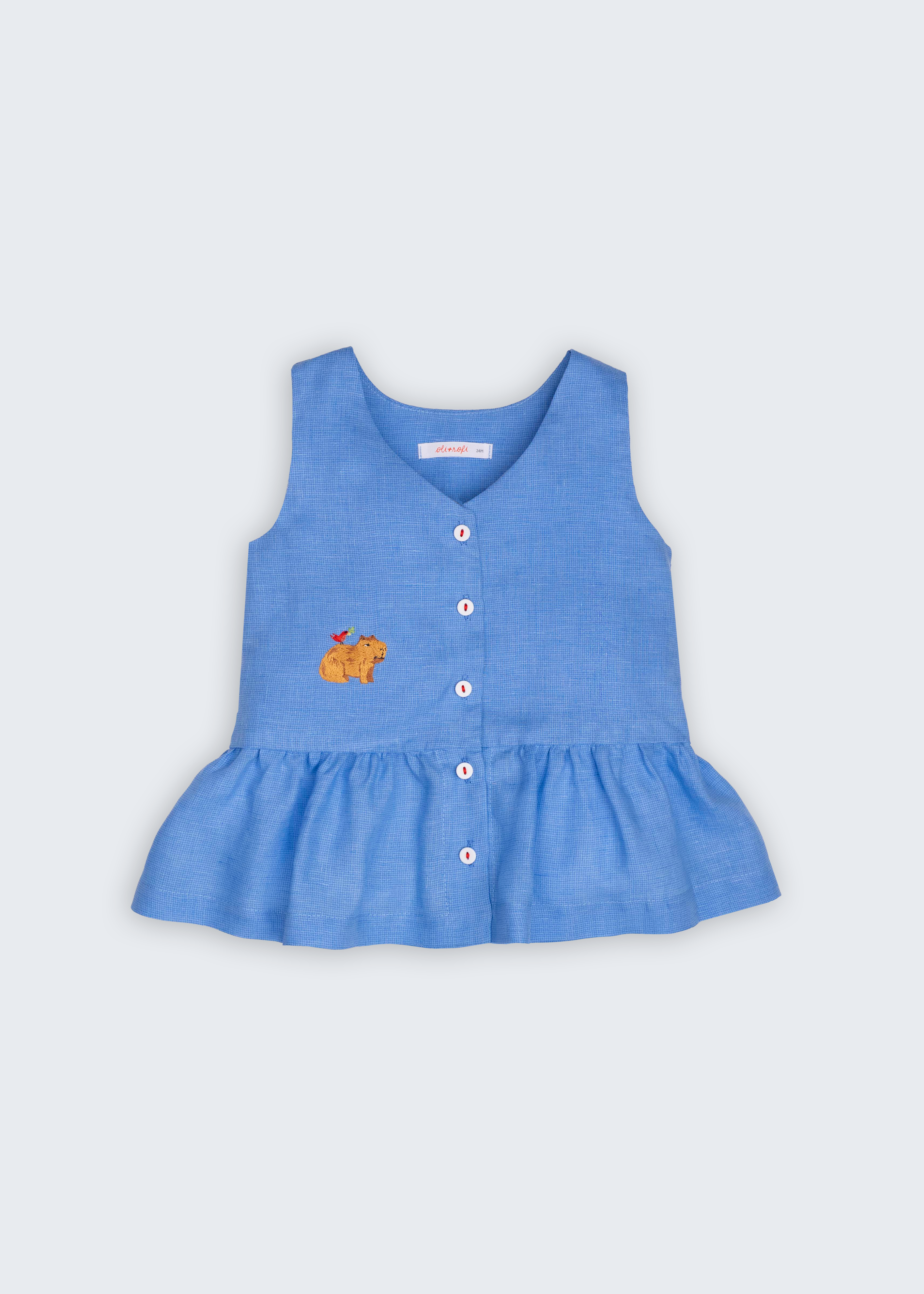 Bata Lola infantil em linho puro azul com capivara bordada à mão e barra franzida, vista de frente