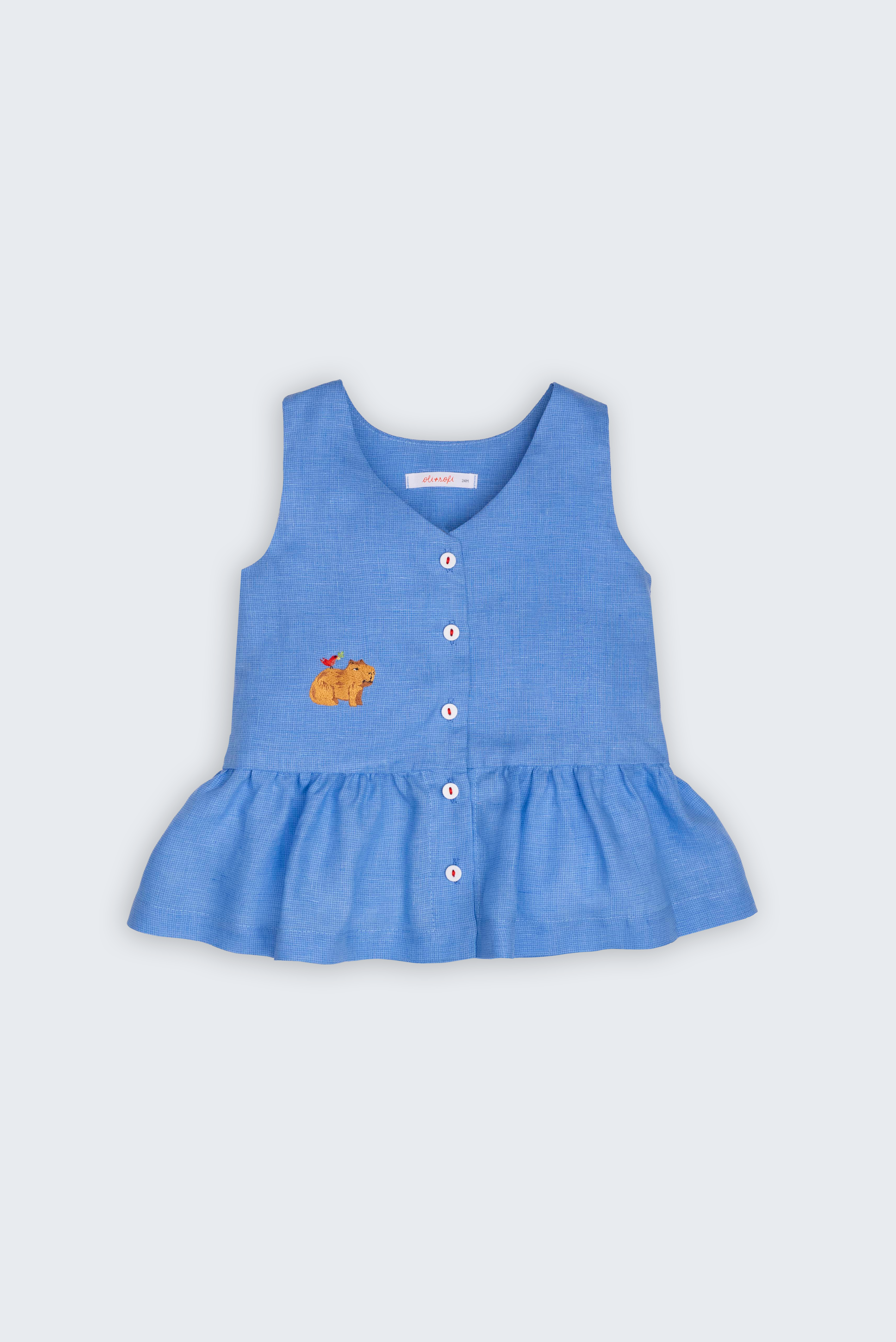 Bata Lola infantil em linho puro azul com capivara bordada à mão e barra franzida, vista de frente