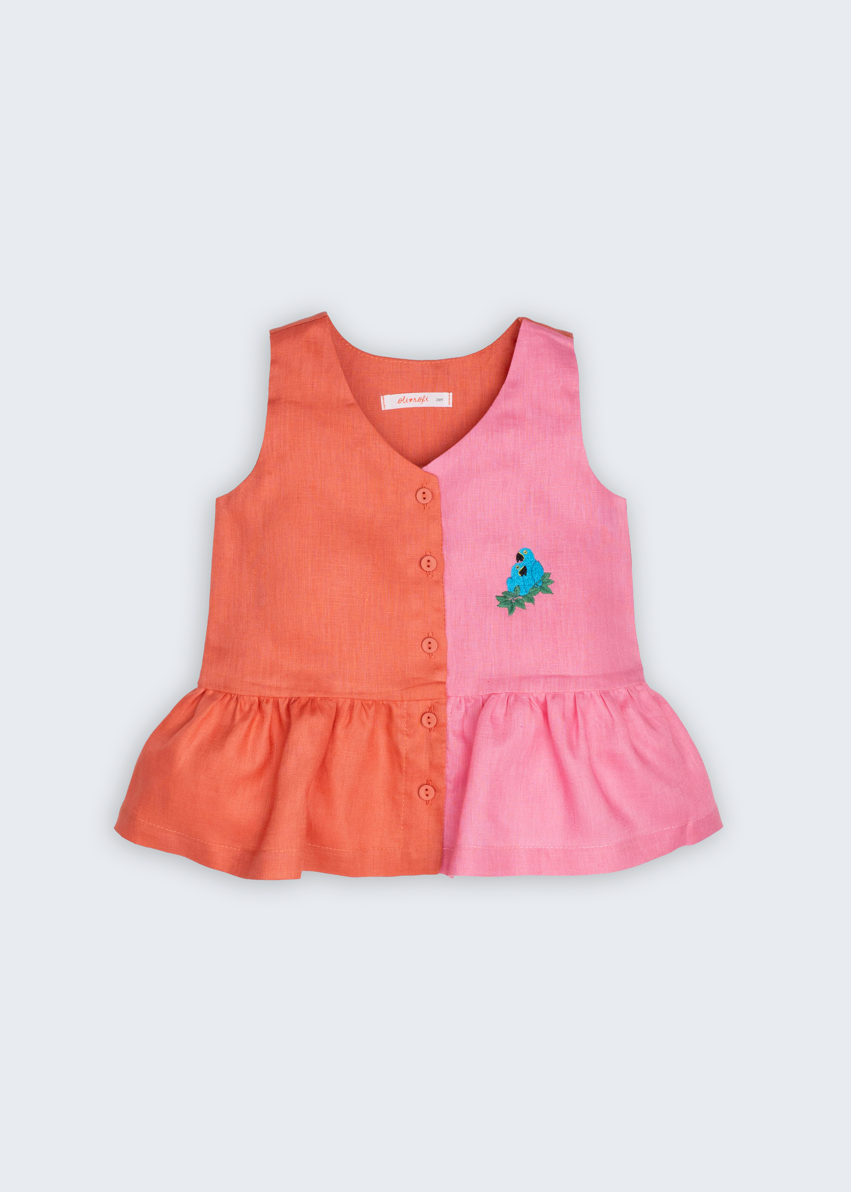 Bata Lola infantil em 100% linho rosa e coral, vista frontal, com botões, barra franzida e bordado de araras-azuis.