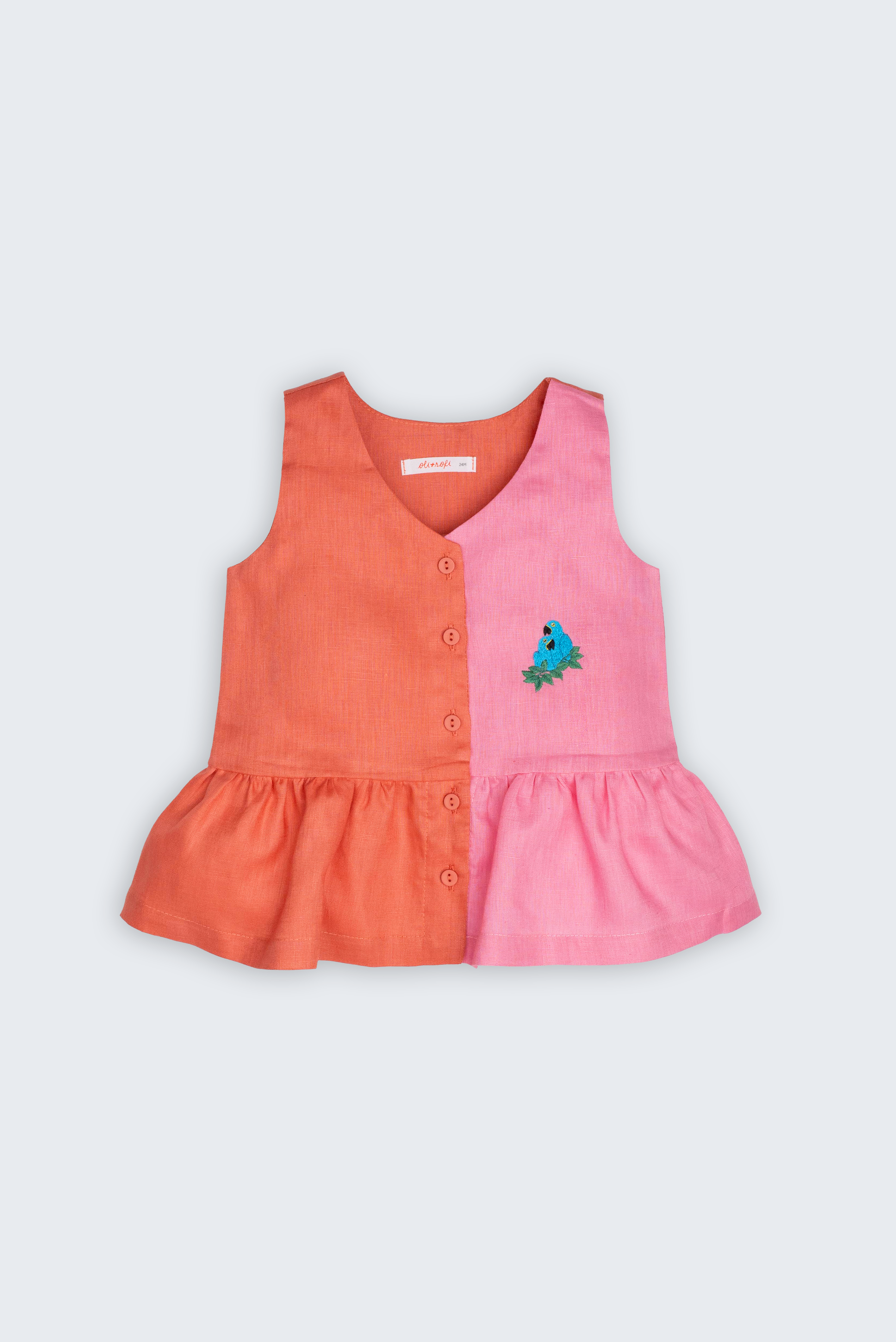 Bata Lola infantil em 100% linho rosa e coral, vista frontal, com botões, barra franzida e bordado de araras-azuis.