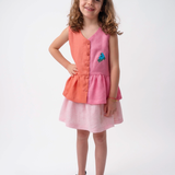 Menina usando Bata Lola infantil em linho bicolor rosa e coral com bordado de araras-azuis