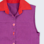 Camisa feminina sem mangas em linho roxo com gola vermelha e abotoamento bordado com conchas e cavalos-marinhos, vista em detalhe.