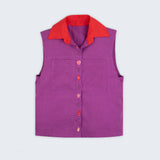 Camisa em linho roxo com gola vermelha contrastante e bordados à mão de elementos do mar entre os botões, vista de frente em still.