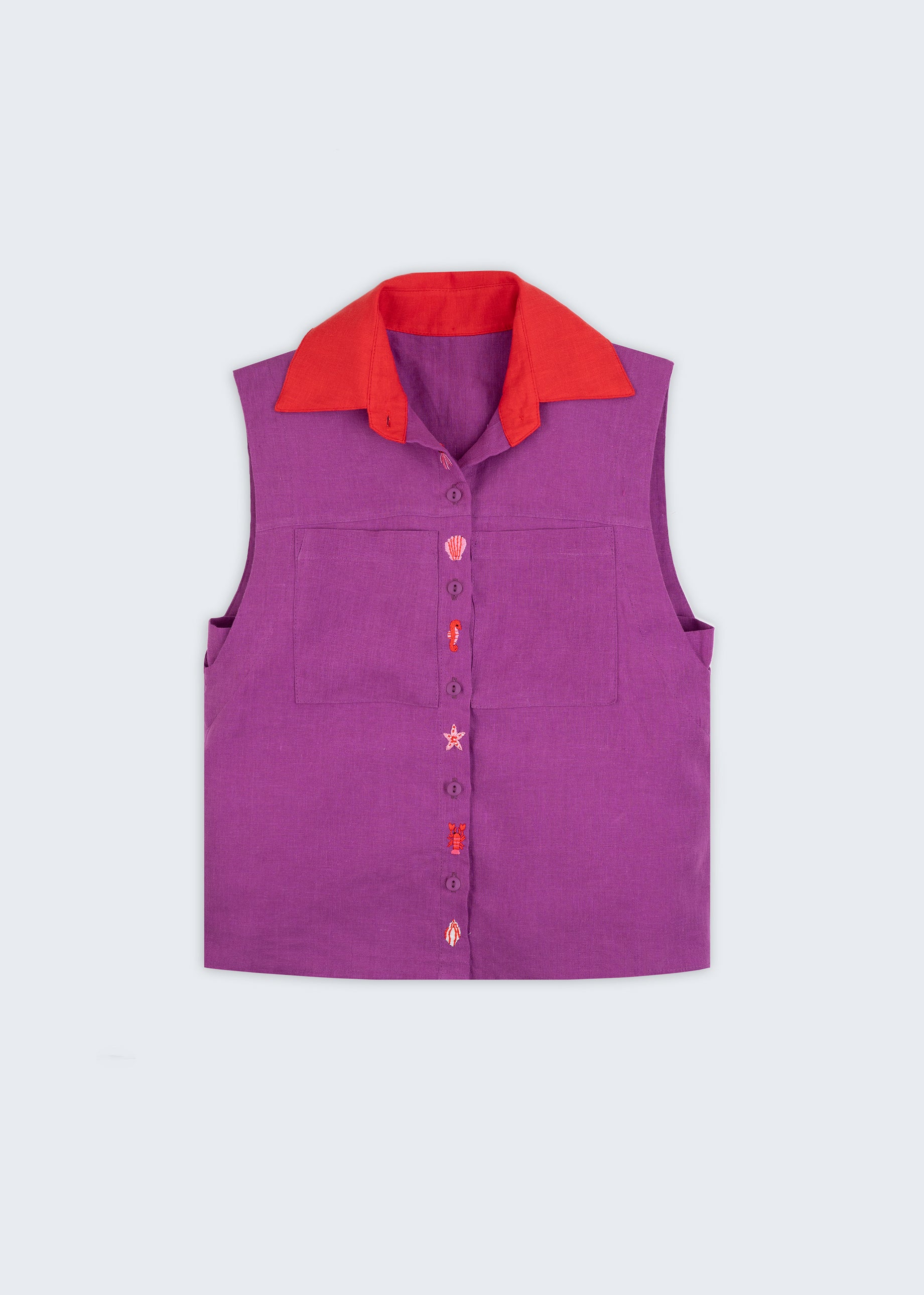 Camisa em linho roxo com gola vermelha contrastante e bordados à mão de elementos do mar entre os botões, vista de frente em still.