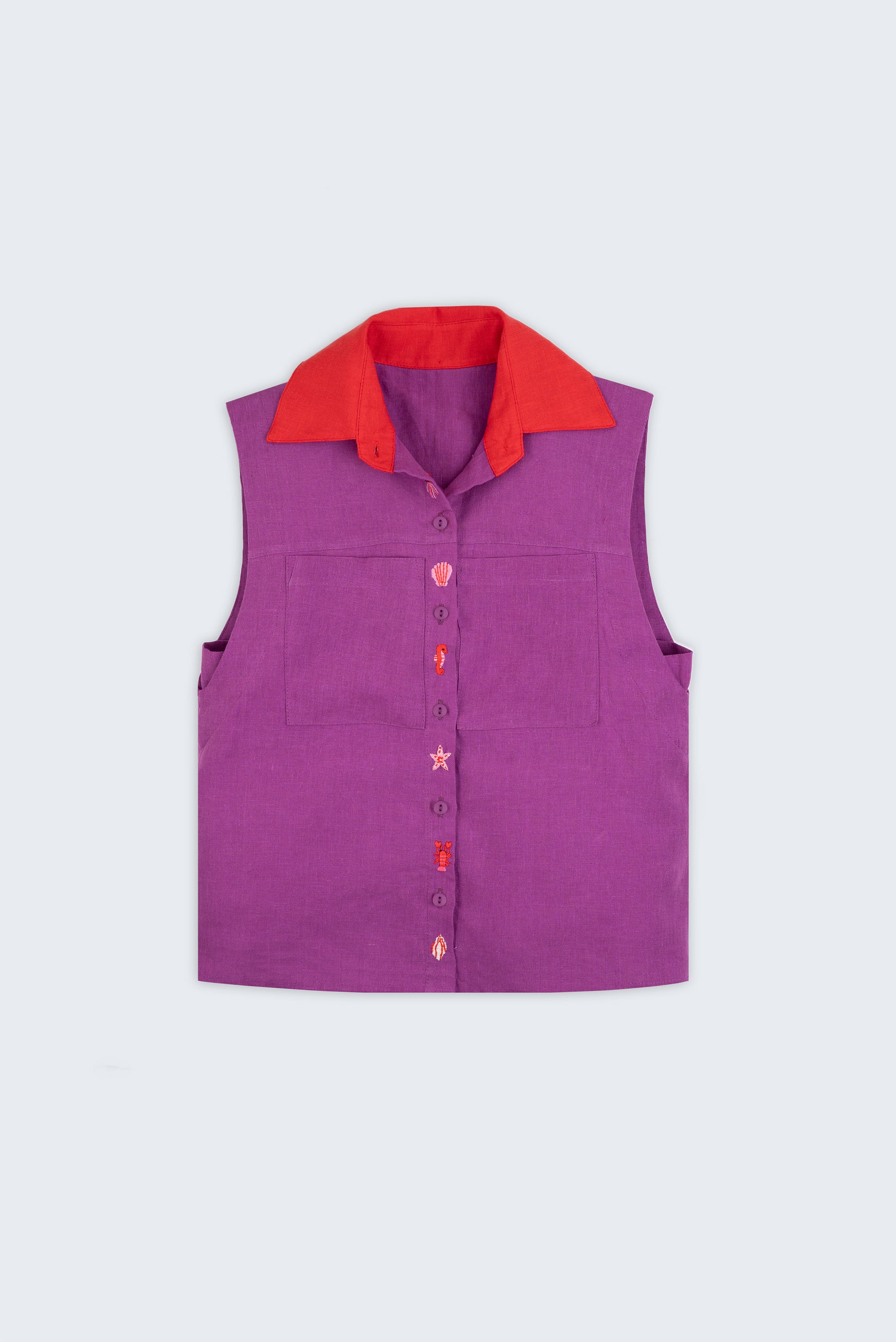 Camisa em linho roxo com gola vermelha contrastante e bordados à mão de elementos do mar entre os botões, vista de frente em still.