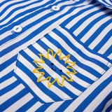 Detalhe do bolso da Camisa Gil em algodão listrado azul e branco com sol amarelo bordado à mão.