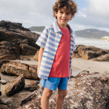 Menino com camisa infantil listrada azul em com peixes bordados, em sobreposição de camiseta.