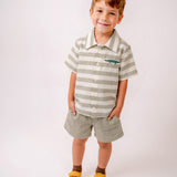Menino vestindo camisa infantil listrada verde oliva e off-white de algodão com bordado de jacaré e shorts verde oliva da Oli e Sofi
