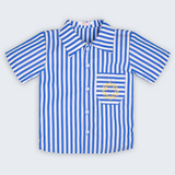 Camisa Gil infantil listrada azul e branca, vista frontal, com gola, mangas curtas, bolso e sol bordado à mão.