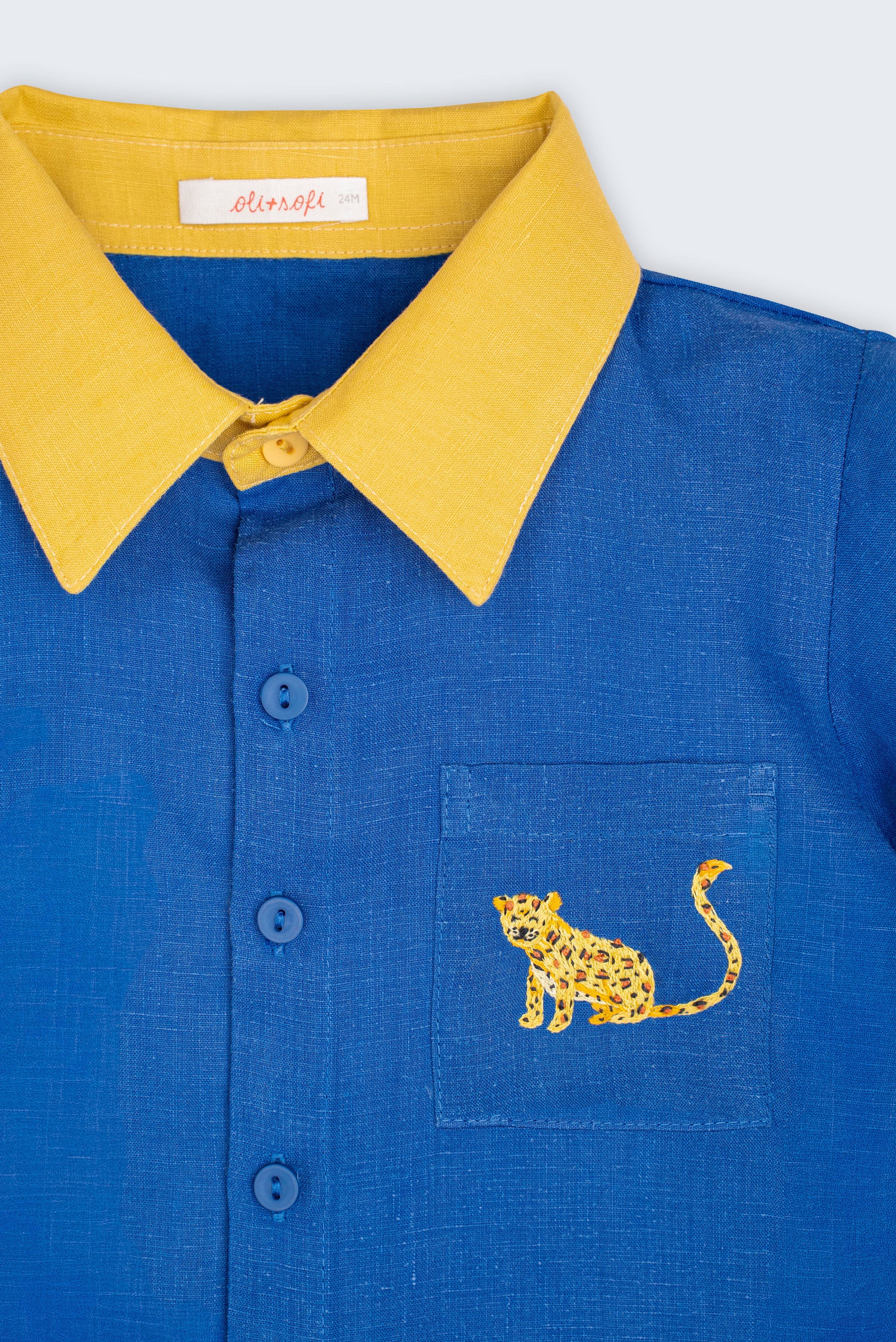 Detalhe da Camisa Tom infantil em linho azul com gola amarela, botões azuis e onça bordada à mão no bolso