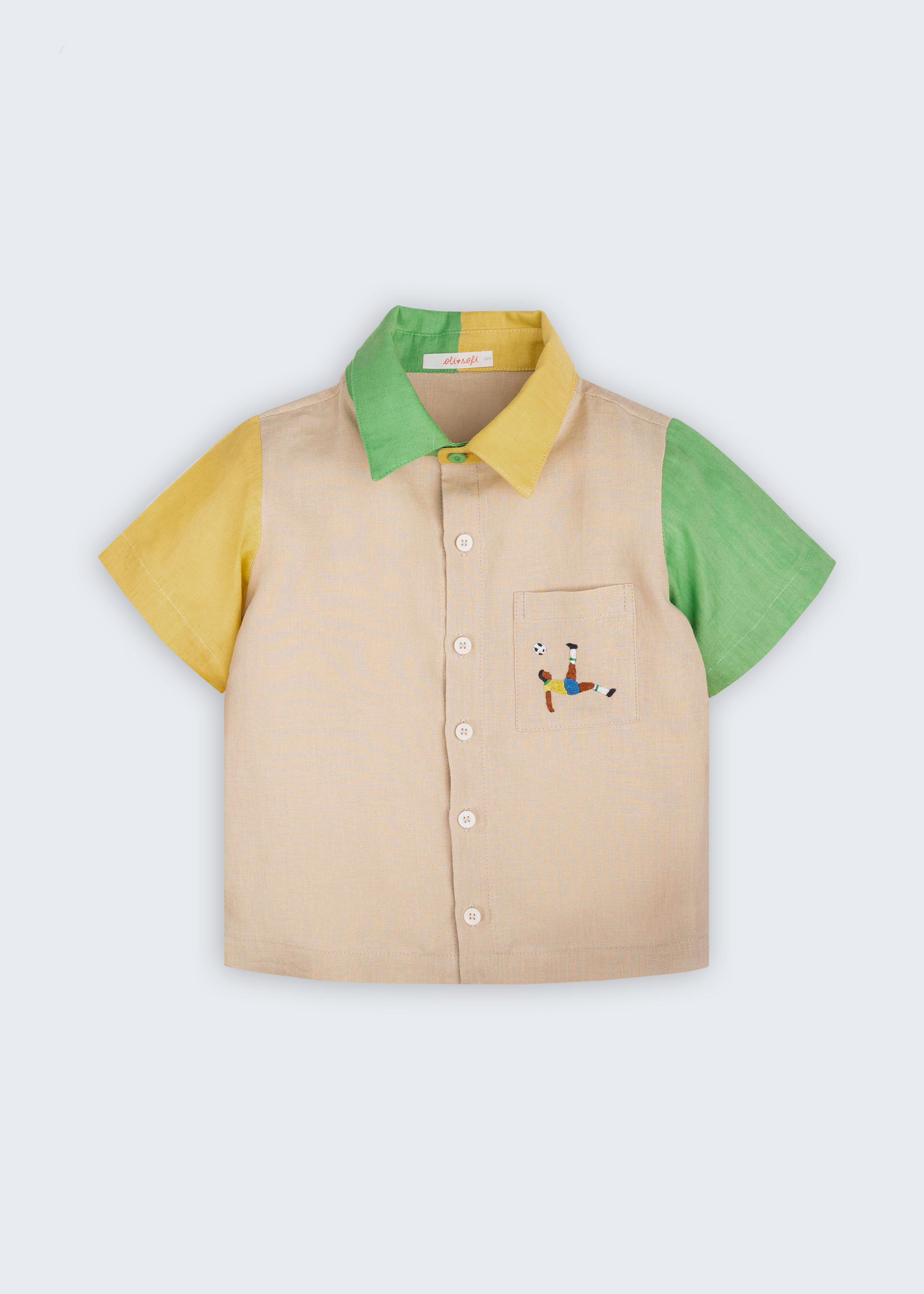 Camisa infantil em linho puro bege com mangas verde e amarela, gola bicolor e bordado de jogador de futebol no bolso, vista de frente