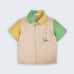 Camisa infantil em linho puro bege com mangas verde e amarela, gola bicolor e bordado de jogador de futebol no bolso, vista de frente