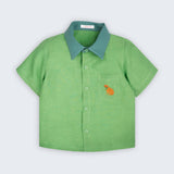 Camisa infantil Tom em linho verde com gola verde aspargo e cachorro caramelo bordado à mão no bolso frontal, vista de frente
