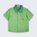 Camisa infantil Tom em linho verde com gola verde aspargo e cachorro caramelo bordado à mão no bolso frontal, vista de frente