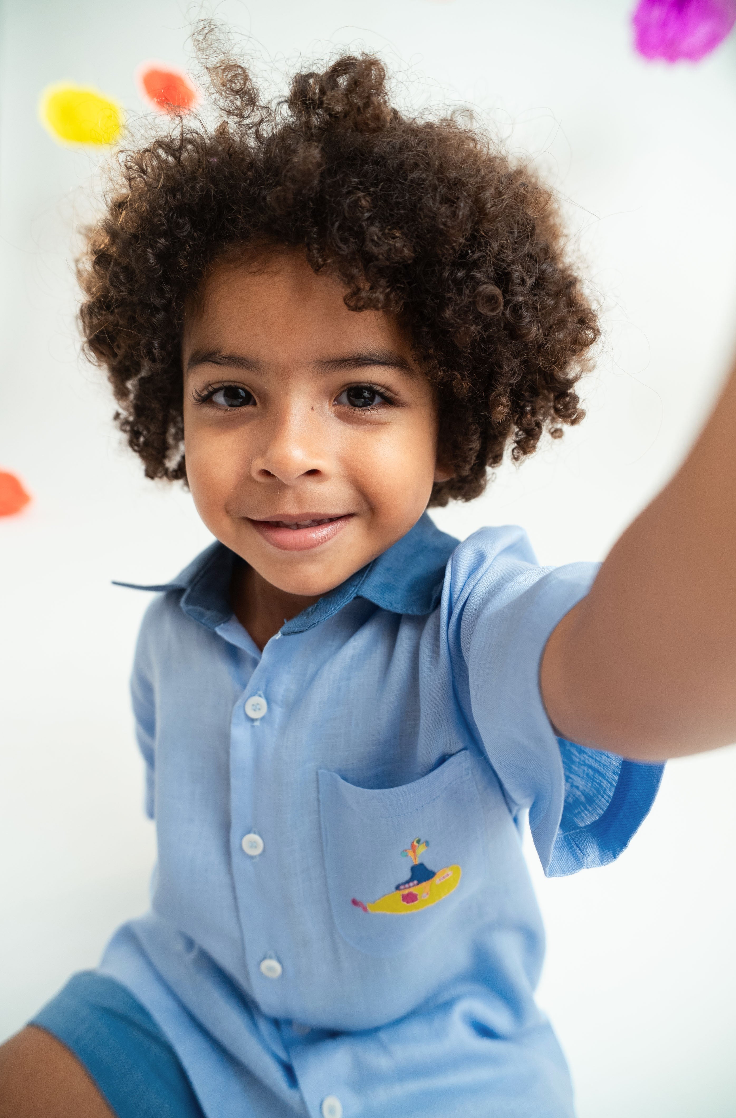 Close de menino usando camisa infantil em linho puro azul claro com bordado Yellow Submarine