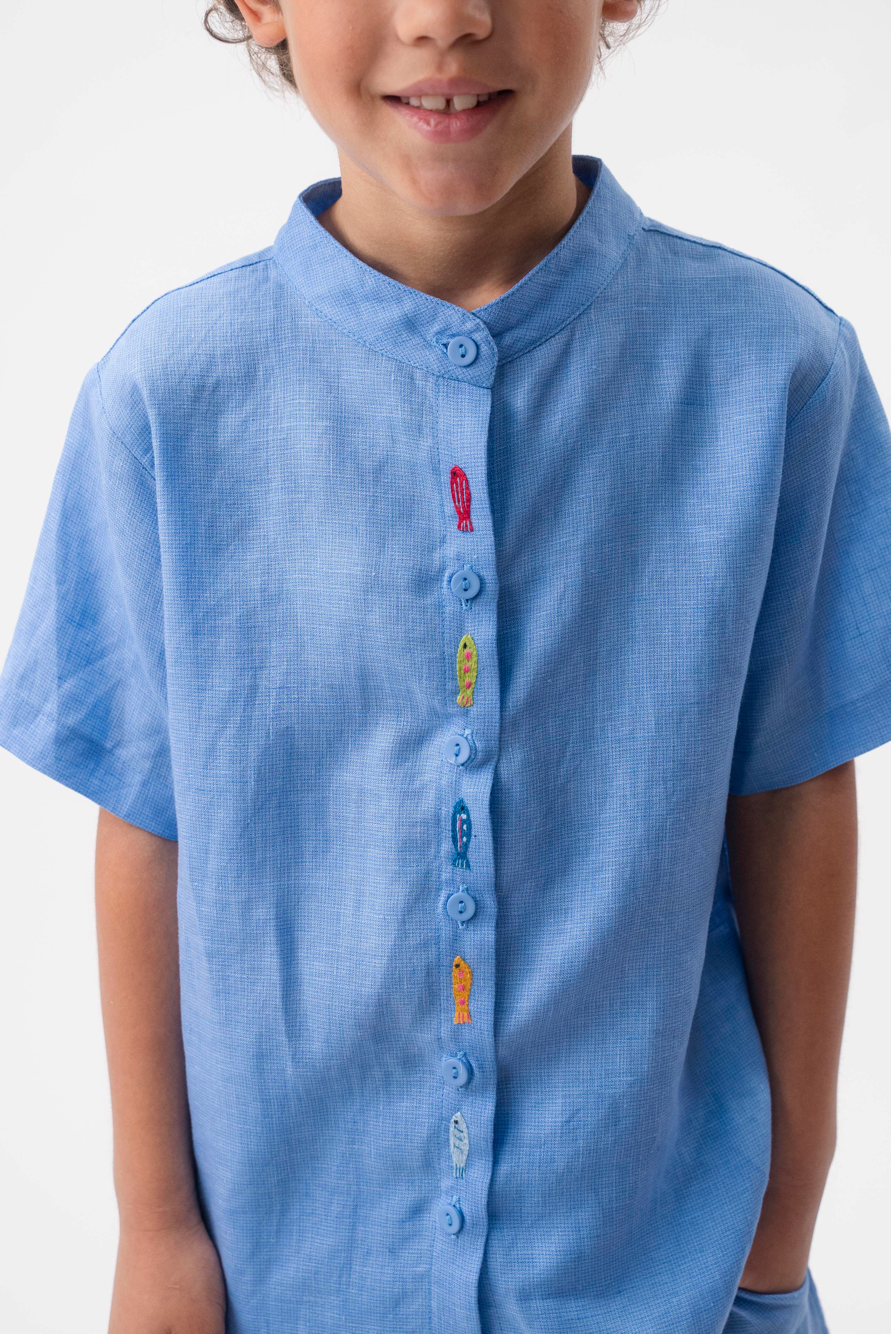 Detalhe da Camisa Bento vestida, com peixinhos coloridos bordados ao longo do fechamento frontal.