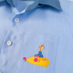 Detalhe do bordado à mão de Yellow Submarine na camisa infantil em linho azul claro
