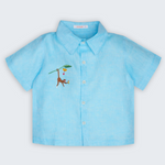 Camisa Tom infantil em 100% linho azul turquesa, vista frontal, com mangas curtas e macaco bordado à mão.