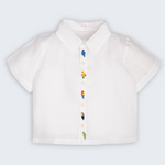 Camisa Tom infantil em 100% linho branco, vista frontal, com aves brasileiras bordadas à mão ao longo do fechamento.
