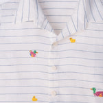 Camisa infantil listrada com patinhos bordados à mão com botões brancos, vista de frente em detalhe