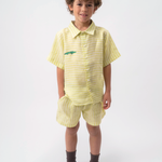 Menino usando Camisa Tom infantil em linho verde listrado com jacaré bordado, combinada com shorts no mesmo tecido.
