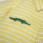Detalhe da Camisa Tom infantil em linho listrado verde e branco com jacaré bordado à mão.