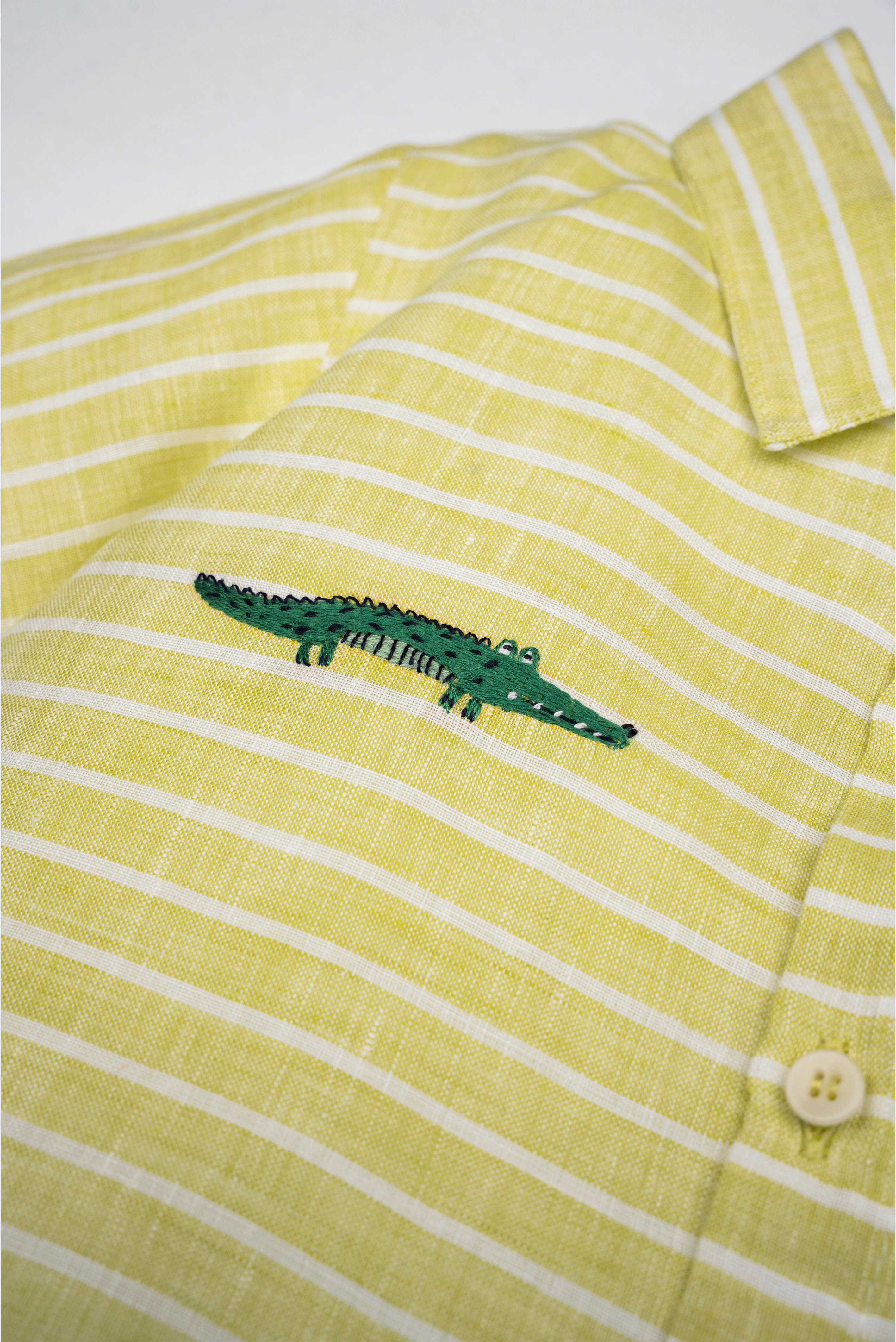 Detalhe da Camisa Tom infantil em linho listrado verde e branco com jacaré bordado à mão.