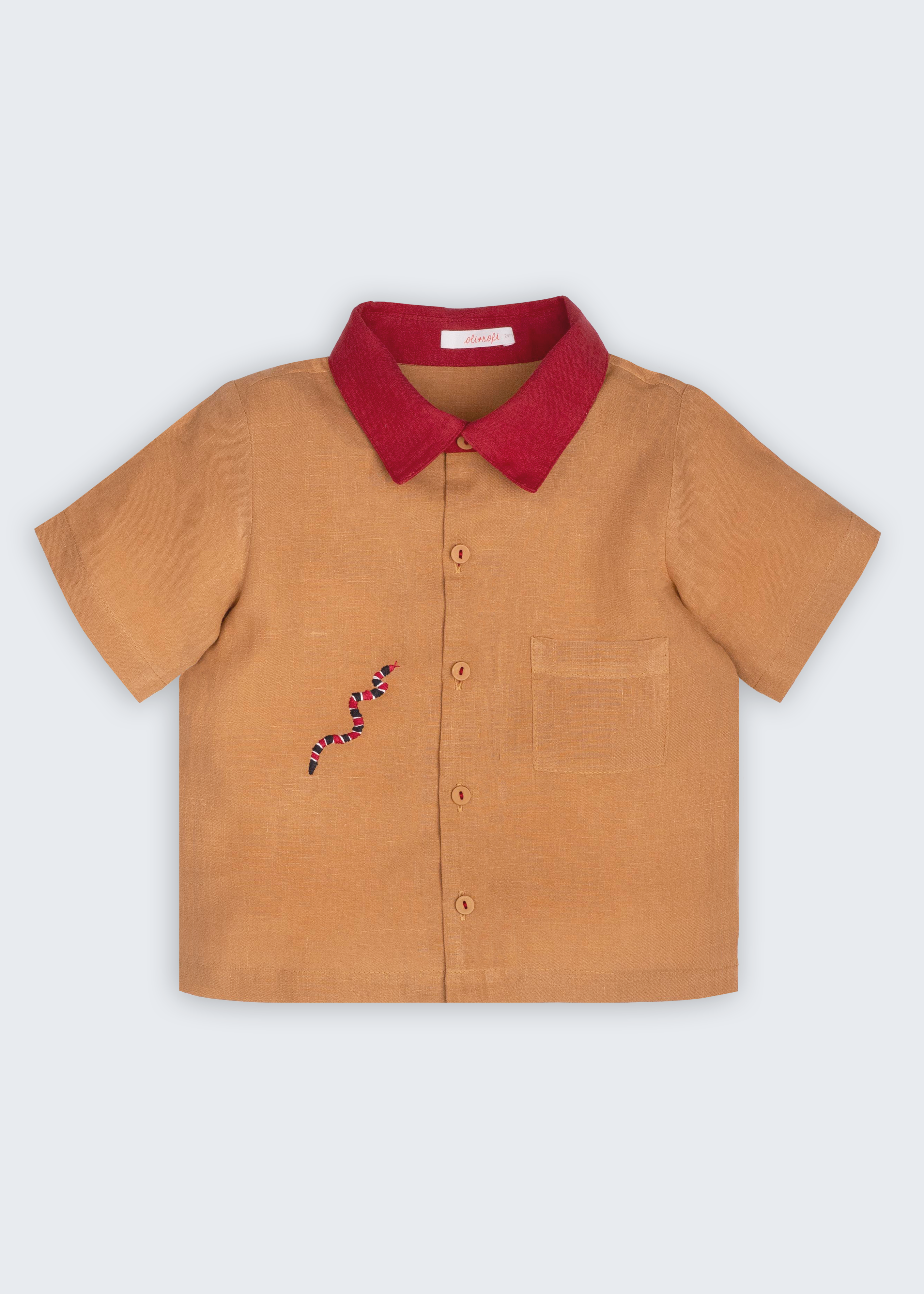 Camisa Luca infantil em 100% linho caramelo com gola vermelha, bolso frontal e cobra-coral bordada à mão, vista frontal.