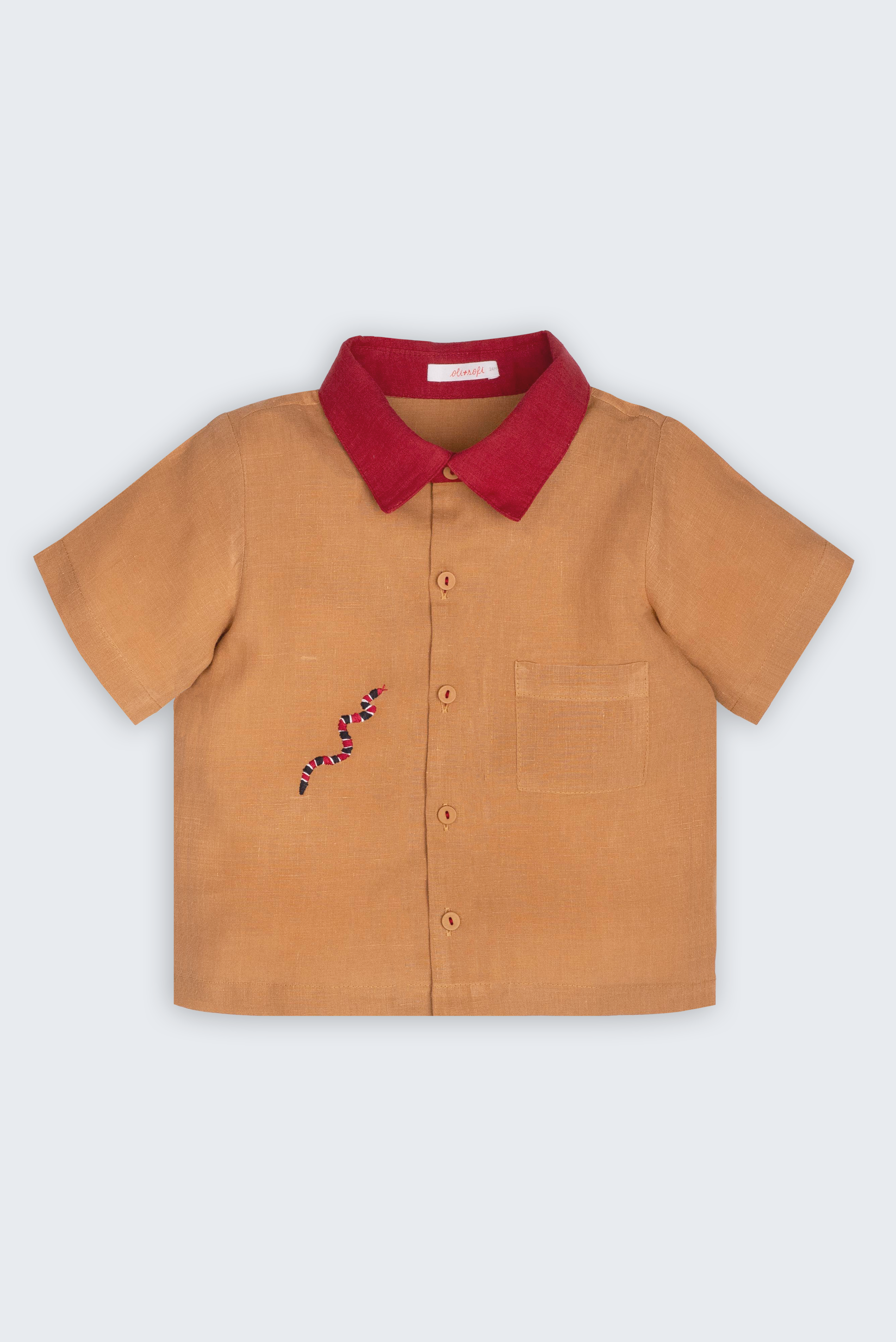 Camisa Luca infantil em 100% linho caramelo com gola vermelha, bolso frontal e cobra-coral bordada à mão, vista frontal.