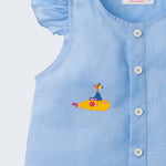 Close de camisa azul infantil em linho com botões brancos frontais e manga de babado, bordada à mão com submarino amarelo dos Beatles.