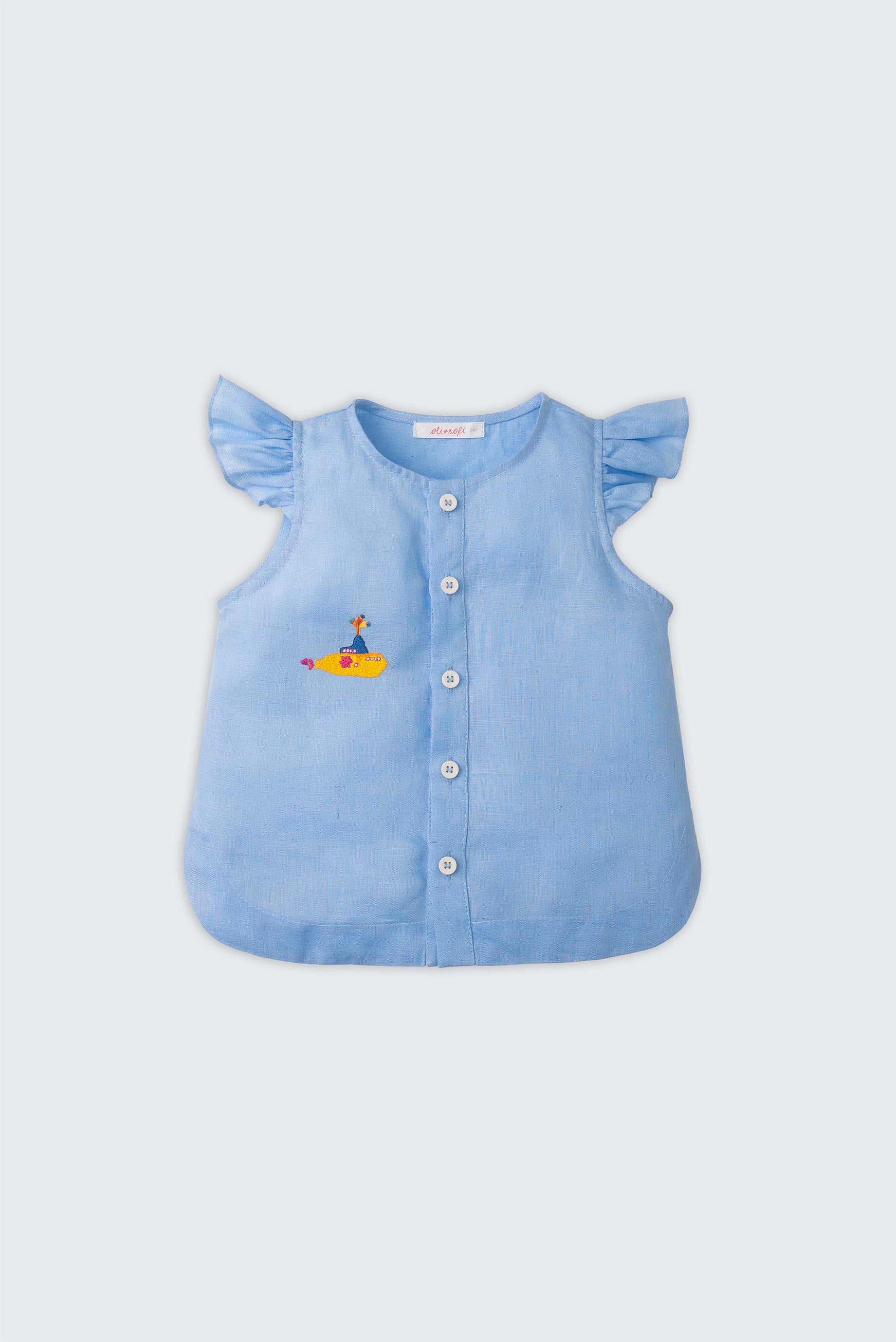 Camisa infantil menina em linho azul com babado nas mangas e bordado à mão de submarino amarelo inspirado em Yellow Submarine, dos Beatles, vista de frente.
