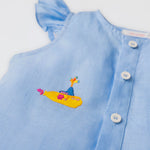 Detalhe do bordado manual de submarino amarelo inspirado em Yellow Submarine, dos Beatles, em camisa azul infantil de linho.