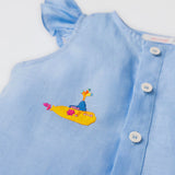 Detalhe do bordado manual de submarino amarelo inspirado em Yellow Submarine, dos Beatles, em camisa azul infantil de linho.