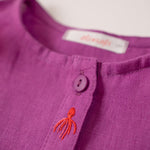 Detalhe do bordado à mão de polvo e da camisa infantil menina em linho roxo com bordados de bichinhos do fundo do mar.