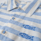 Detalhe dos peixes bordados à mão nas listras azuis da camisa infantil.