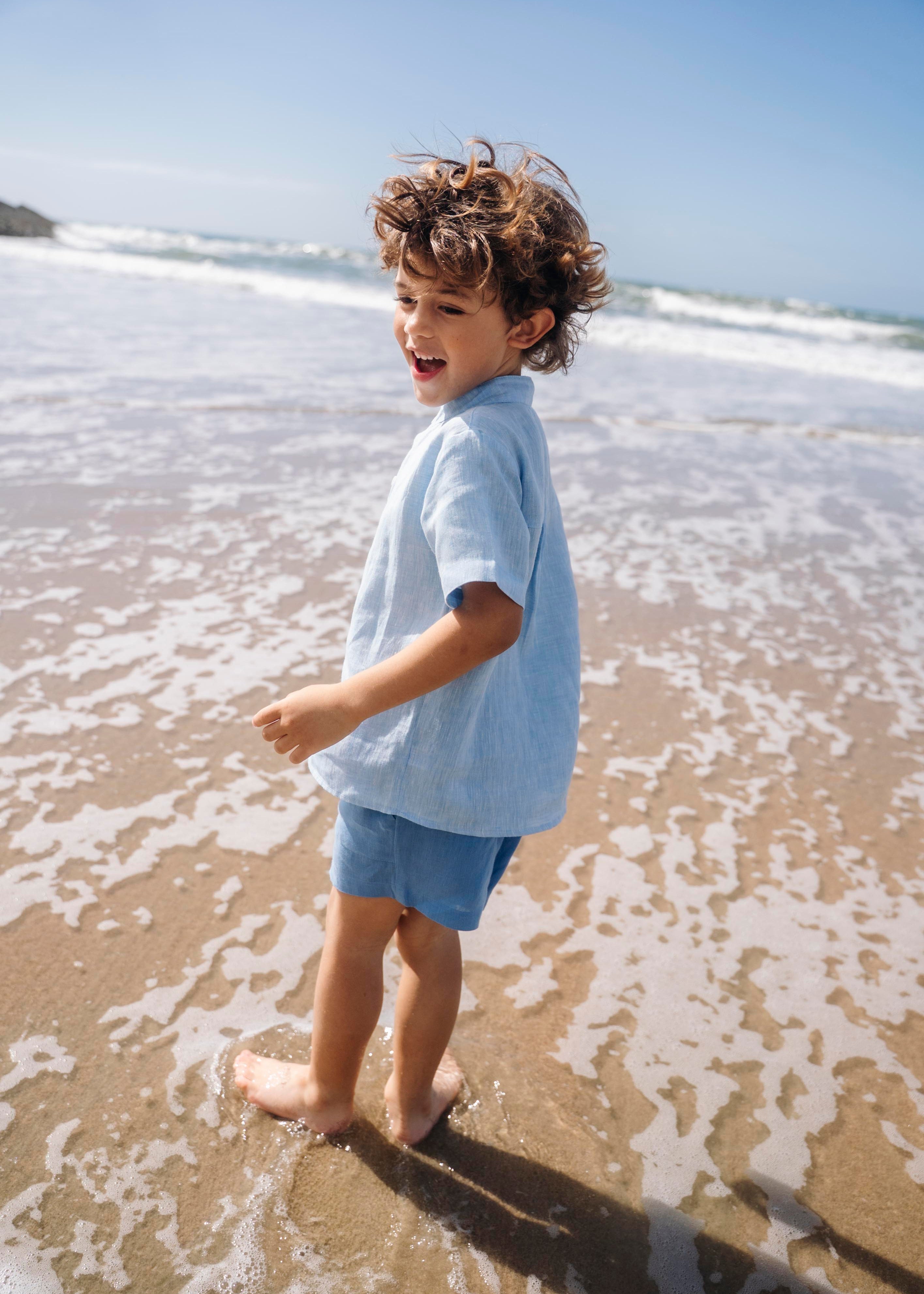 Camisa infantil de linho azul vista de costas no corpo.