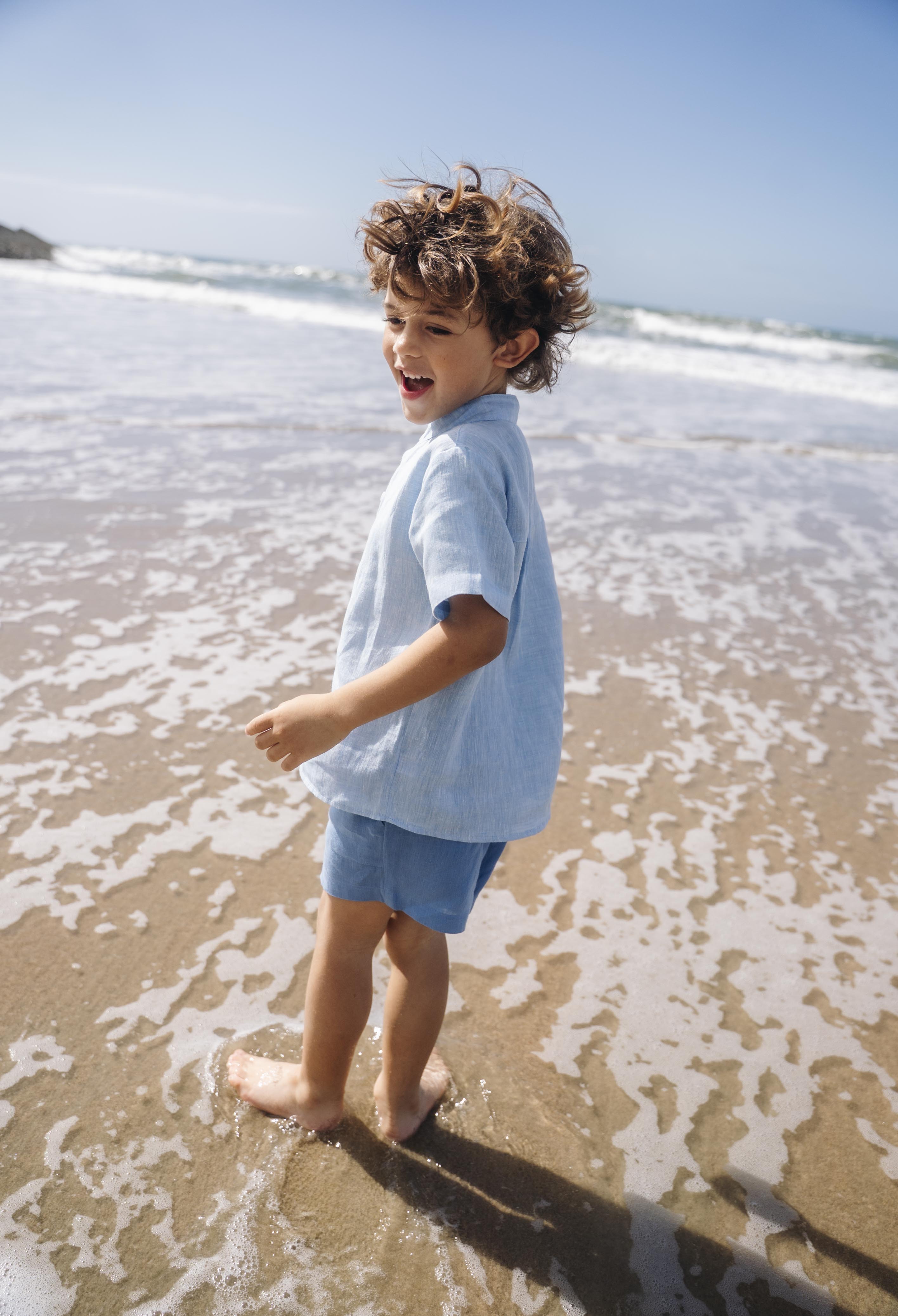 Camisa infantil de linho azul vista de costas no corpo.
