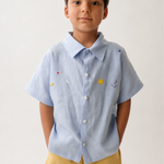 Menino vestindo camisa Tom em puro linho azul claro com bordado manual inspirado no céu e nos astros.