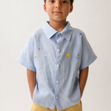 Menino vestindo camisa Tom em puro linho azul claro com bordado manual inspirado no céu e nos astros.