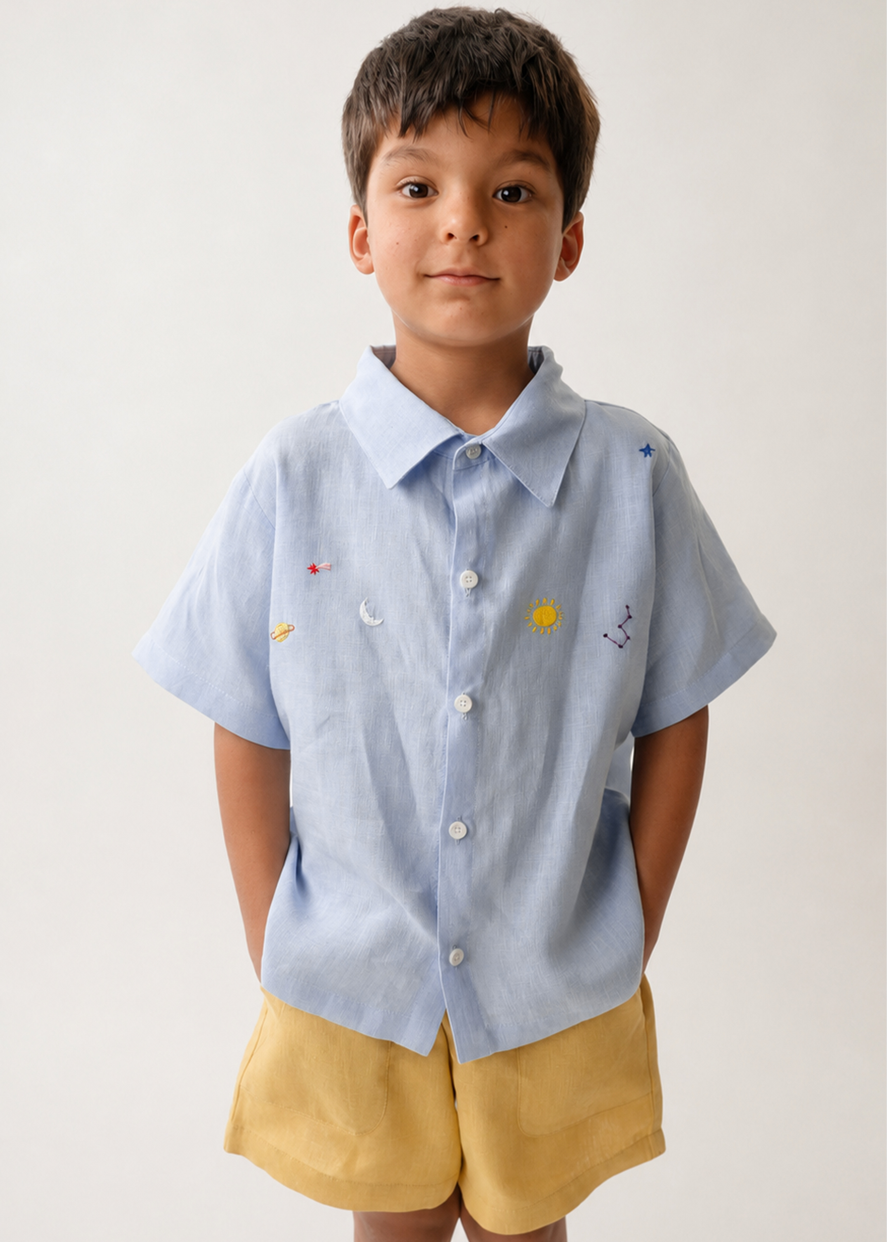 Menino vestindo camisa Tom em puro linho azul claro com bordado manual inspirado no céu e nos astros.