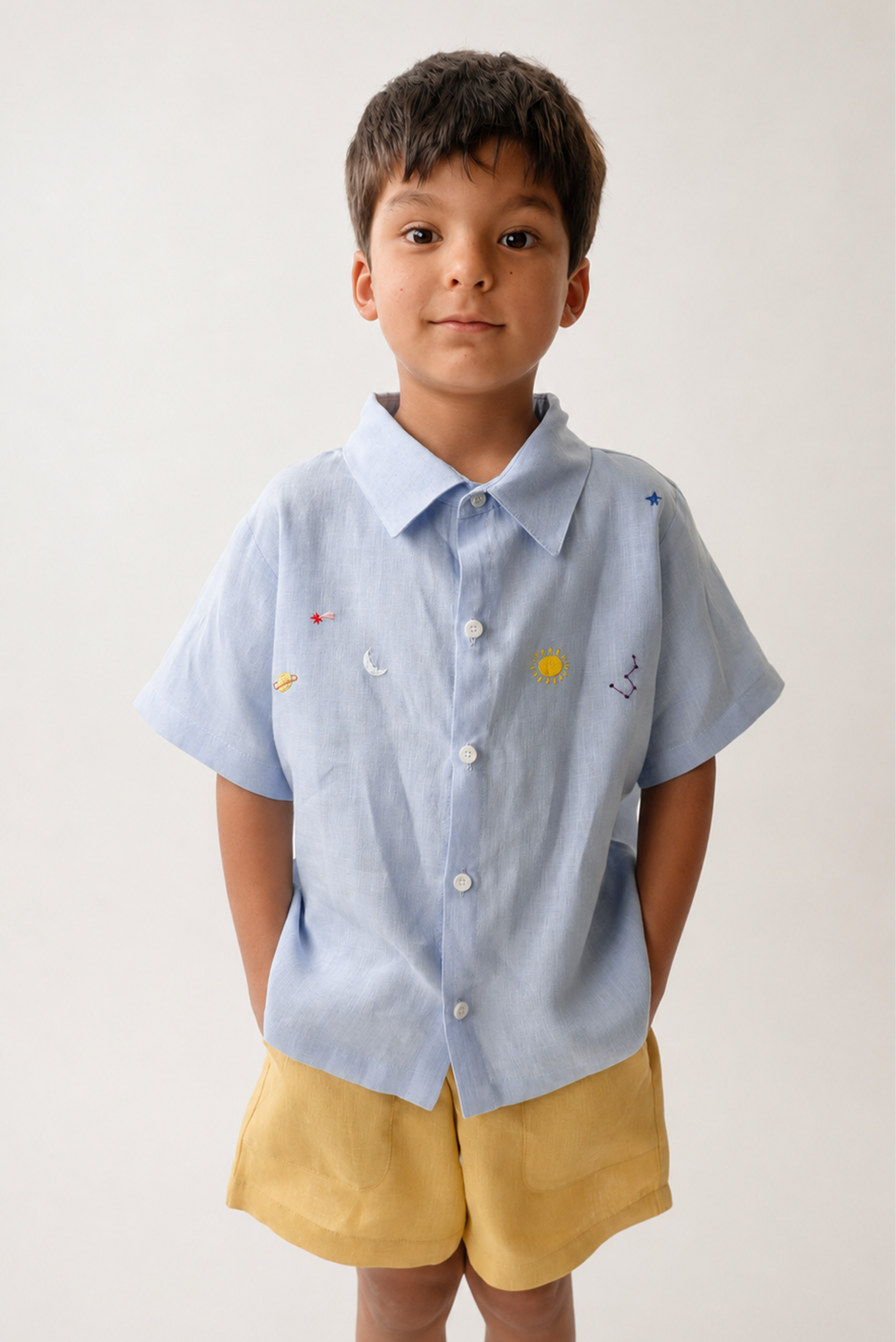 Menino vestindo camisa Tom em puro linho azul claro com bordado manual inspirado no céu e nos astros.