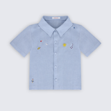 Camisa infantil para menino em puro linho azul claro com bordado à mão de sol, lua, planeta, estrelas e foguete, vista frontal.