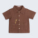 Camisa infantil de menino em linho marrom com bolsos frontais e bordado artesanal de girafa.