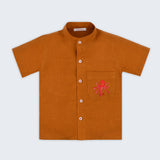 Camisa infantil em linho puro terracota com polvo bordado à mão no bolso, vista de frente; para meninos e meninas.