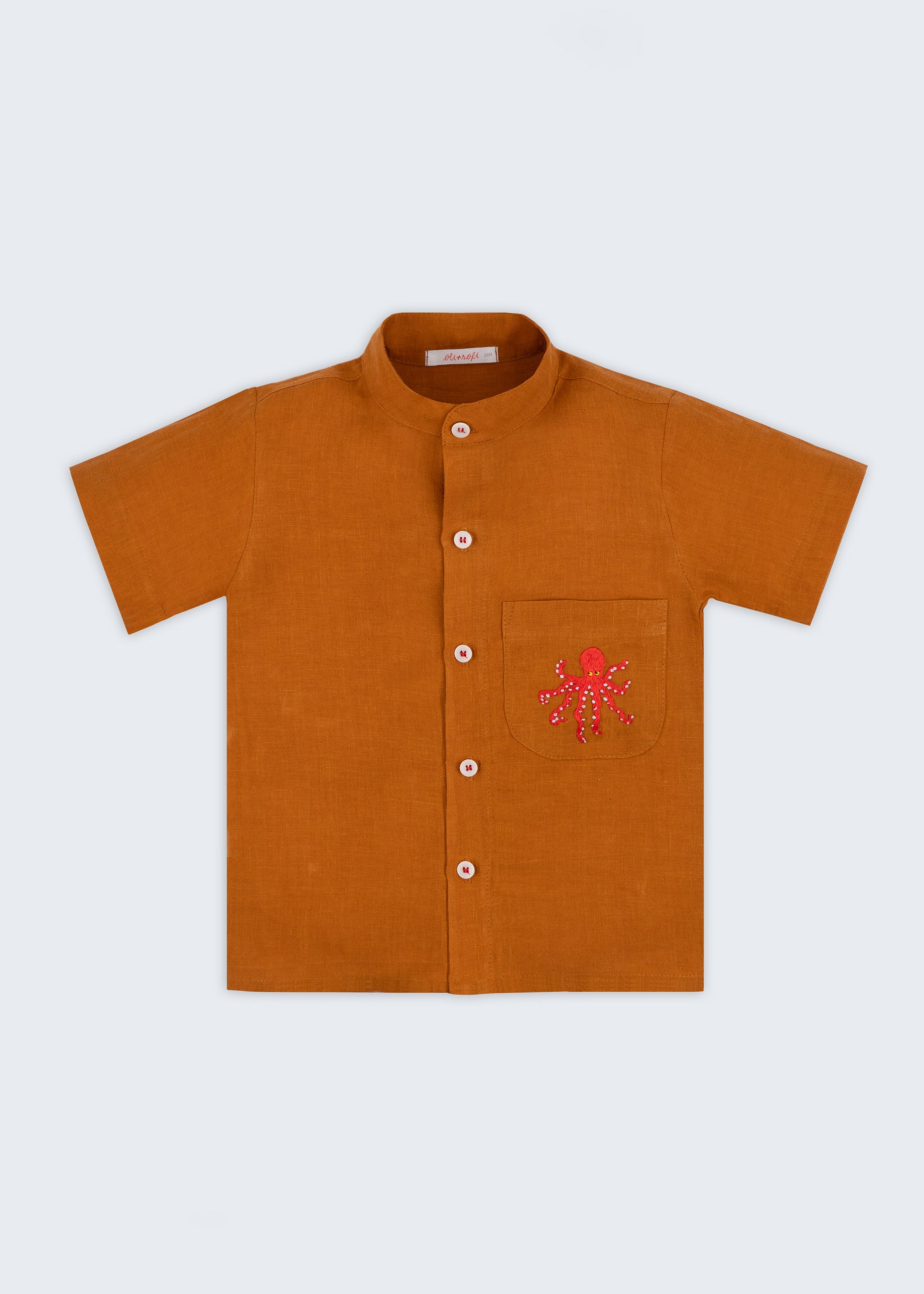 Camisa infantil em linho puro terracota com polvo bordado à mão no bolso, vista de frente; para meninos e meninas.