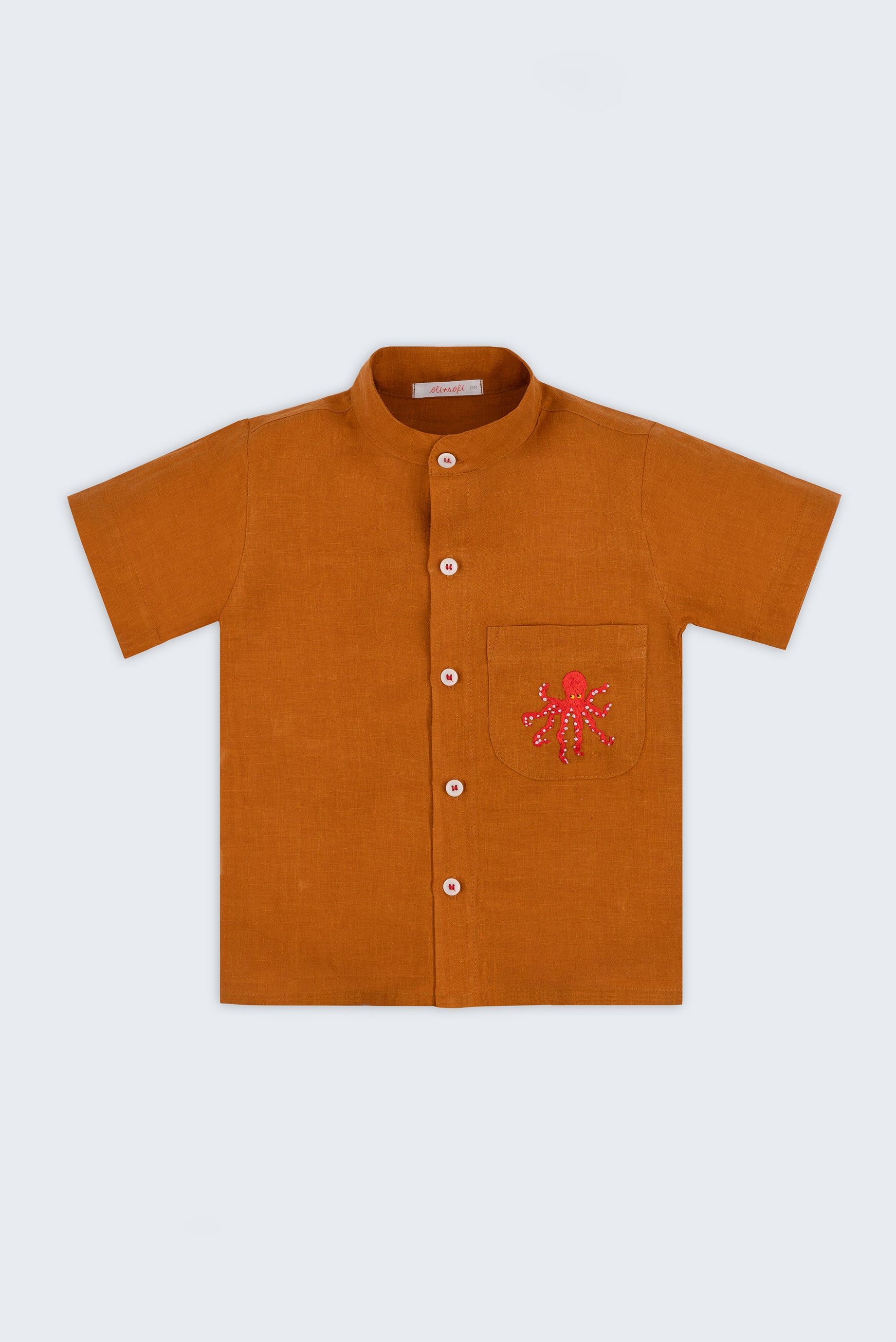 Camisa infantil em linho puro terracota com polvo bordado à mão no bolso, vista de frente; para meninos e meninas.