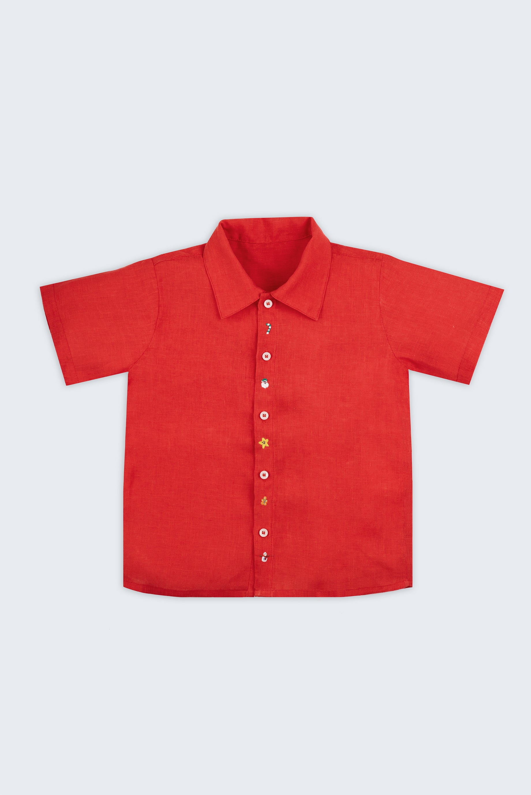 Vista frontal da camisa infantil menino em linho vermelho com pequenos bordados à mão natalinos.
