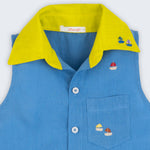 Camisa infantil em linho azul com gola amarelo lima e bordado de barquinhos coloridos espalhados pela pala, ombro e bolso feito à mão, vista de frente em detalhe.