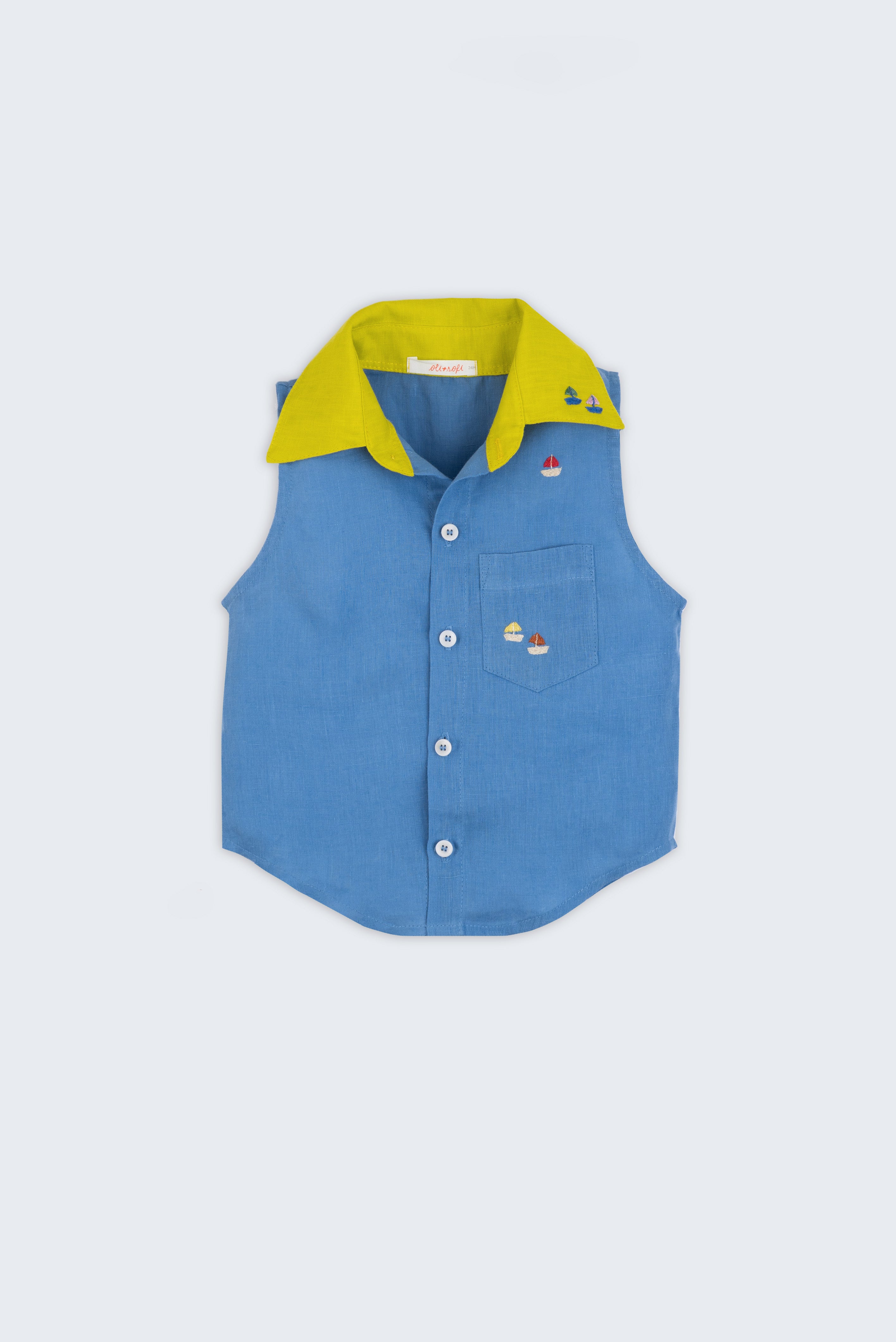 Camisa infantil em linho azul com gola amarelo lima e bordado de barquinhos coloridos espalhados pela pala, ombro e bolso, para meninos e meninas; vista de frente.