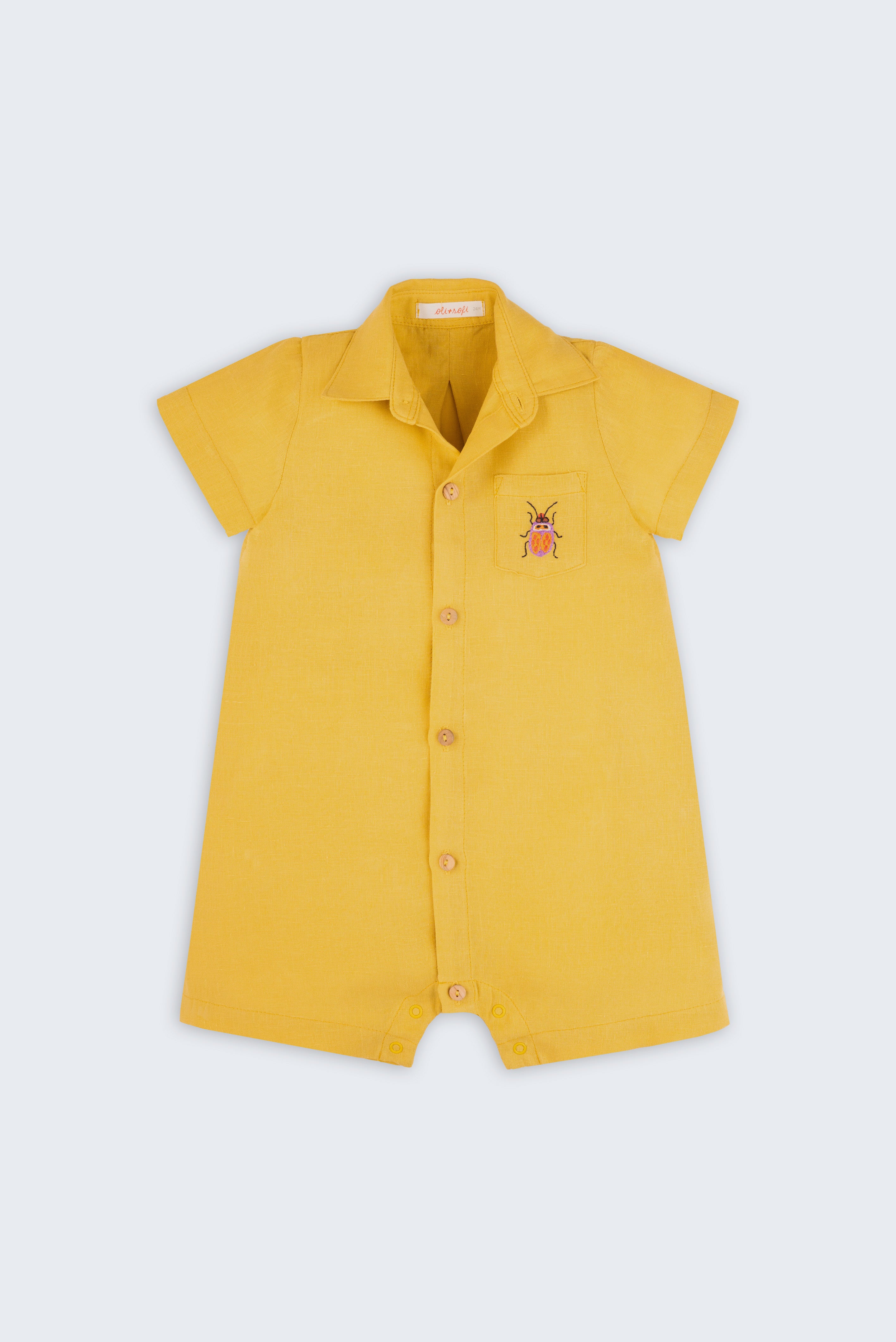 Macacão infantil unissex em linho amarelo com bordado de besouro, visto de frente.
